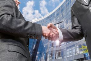 Businessmen shake hands against the background of the business center.